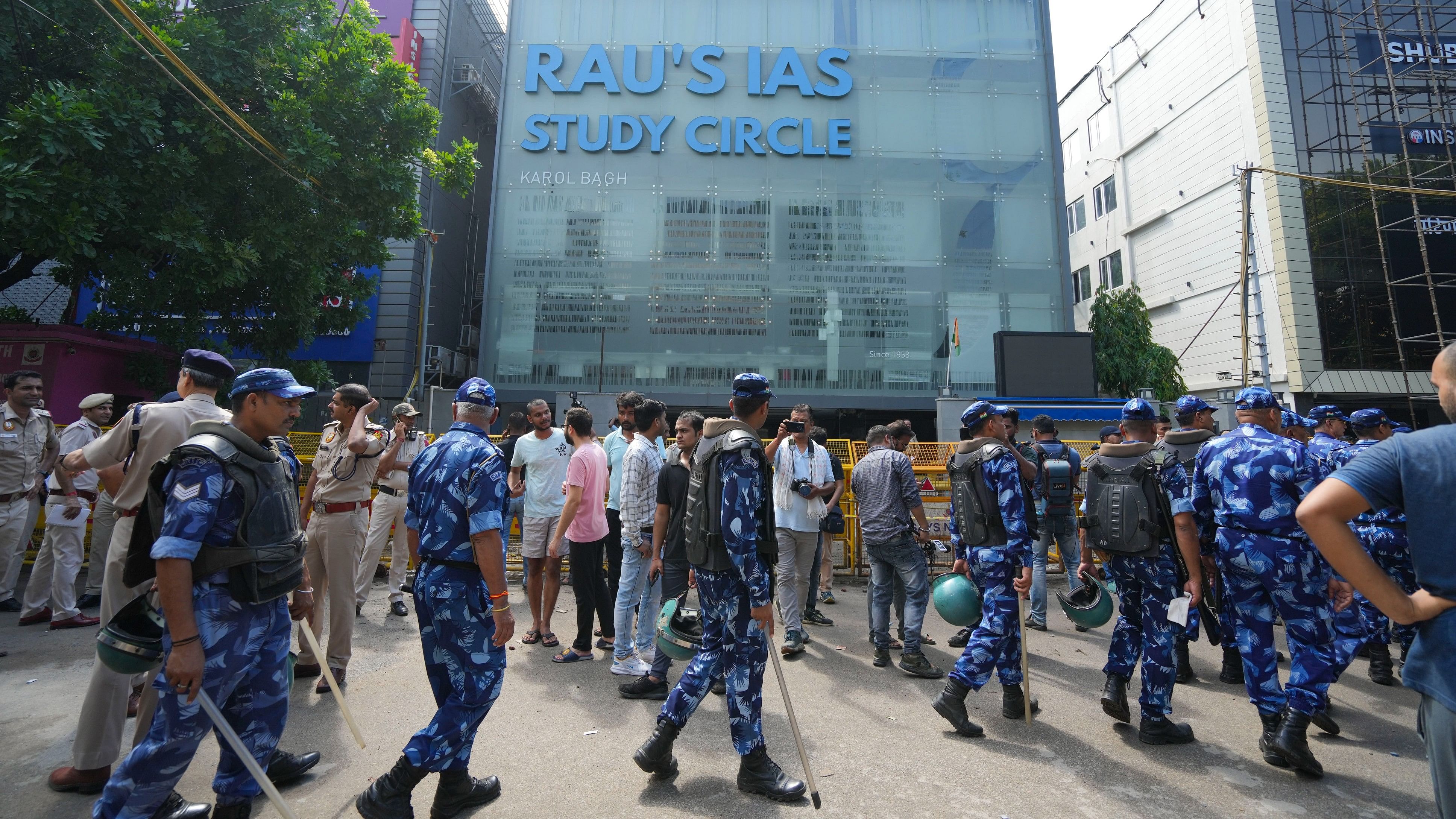 <div class="paragraphs"><p>Security personnel stand guard near a UPSC exam coaching centre after three civil services aspirants died when the basement of the coaching centre was flooded by rainwater, in New Delhi, Sunday.</p></div>